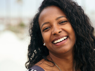 Close up portrait of a young smiling attractive African Latin American woman. Empowered woman, positive emotions