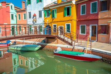 Fototapeta na wymiar Burano island canal reflection, colorful houses and boats, Venetian lagoon