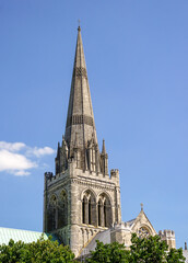 Fototapeta na wymiar tower of impressive stone cathedral. close up of tower and spire of medieval English cathedral on sunny day