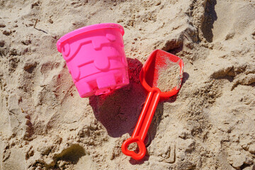 Children's bucket and spade beach toys on sandy beach. colorful bucket and shovel in the sand. items for building sandcastles  © Paul Cartwright