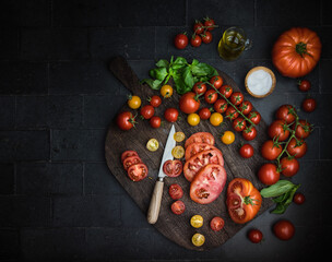 tomatoes on a dark wooden board 