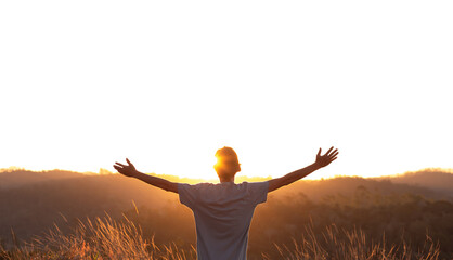 Young man with arms raised thanking God, with the sunset in the background. Concept of happiness...