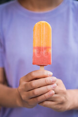Closeup of woman hands holding colorful ice cream. Tasty dessert 