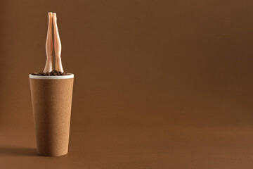 coffee concept, creative minimal art with doll and coffee cup on brown background
