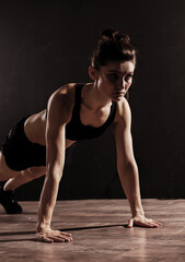 Fototapeta na wymiar Attractive Sporty Young Caucasian Woman Doing Workout Exercise. Low Key Portrait Photo