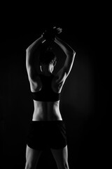 Obraz na płótnie Canvas Attractive Sporty Young Caucasian Woman Doing Workout Exercise. Low Key Portrait Photo
