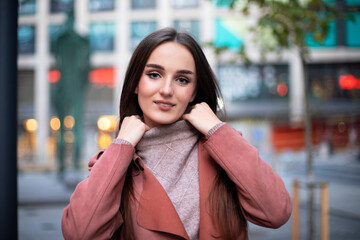 Fototapeta premium Portrait of a model in a sweater with a collar in urban locations on a blurred background.