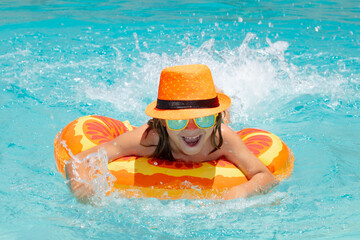 Child boy boy relaxing in pool. Kid swimming in water pool. Summer kids activity, watersports. Fashion summer tanned kid in hat and suglasses.