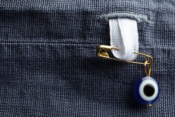 Naklejka premium Evil eye safety pin on clothing, closeup