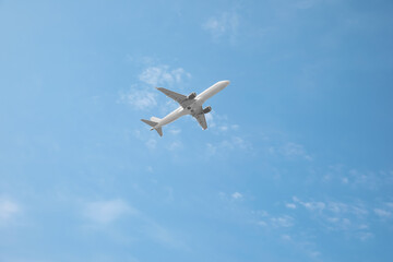Fototapeta na wymiar Modern airplane flying in blue sky low angle view