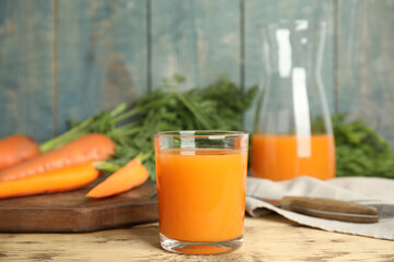 Glass of freshly made carrot juice on wooden table