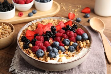 Healthy muesli served with berries on wooden table, closeup