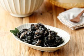 Tumis Cumi Hitam or Stir Fry Squid in Black Ink Sauce. Indonesian Traditional Food Made from Squid with Spicy Seasoning.