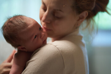 Newborn baby. mother holding baby in her arms flirting with him.