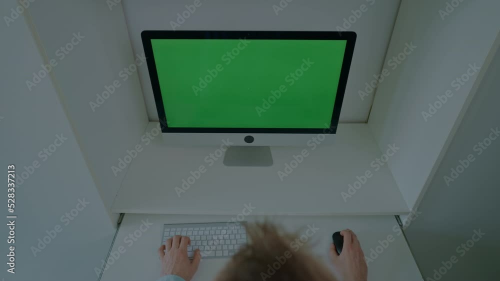 Aufkleber above view man sitting at the desk working typing on keyboard computer with green screen