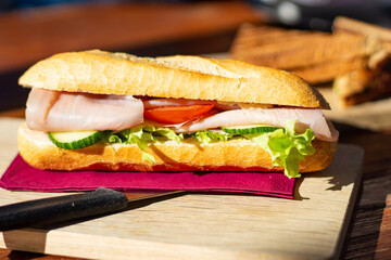 Close up of BLT baguette sandwiches on a wooden plate