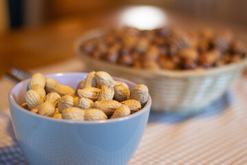 Close up of a bowl of peanuts on a table