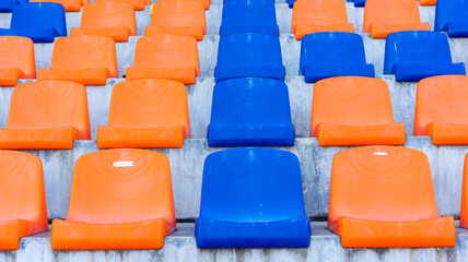 Rows of blue and orange plastic stadium seats.