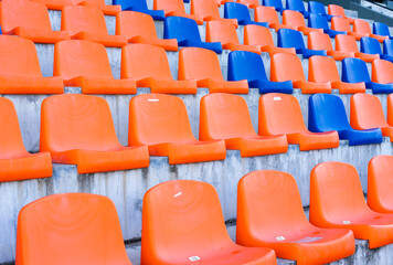 Fototapeta premium Rows of blue and orange plastic stadium seats.