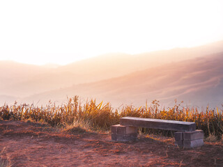 Wooden bench on high mountain at sunrise.