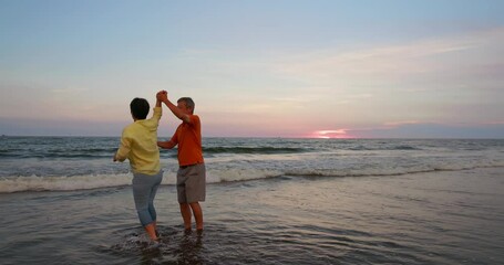 elderly couple dance on beach