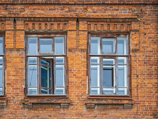 Fototapeta na wymiar Two windows of the old mansion 19 century with brown bricks wall