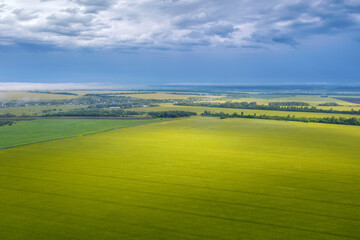 Rural landscape. Aerial view of a field with sunlight on it on rainy summer day. Penza Oblast, Russia.