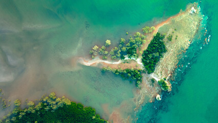 Top-down drone view of rapids of mountain river with wet boulders and pebble shore.