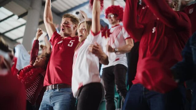 Sport Stadium Big Event: Crowd of Fans Cheer for Red Soccer Team to Win. People Celebrate Scoring a Goal, Championship Victory. Cute Caucasian Couple with Painted Faces Cheer, Shout.