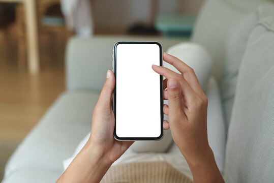 close-up hand using phone showing white screen in living room