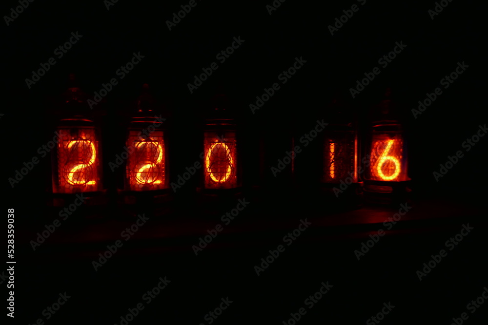 Poster retro nixie lamp indicator clock on dark background. the nixie tube indicator of the numbers of retr