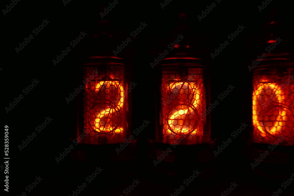 Poster retro nixie lamp indicator clock on dark background. the nixie tube indicator of the numbers of retr