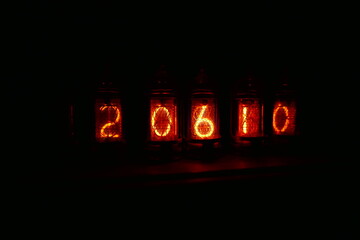Retro Nixie lamp indicator clock on dark background. The Nixie tube indicator of the numbers of...