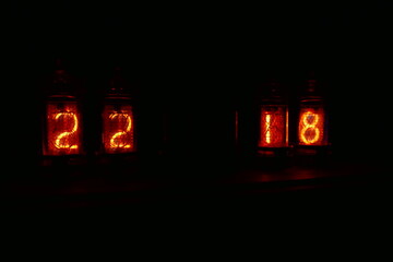 Retro Nixie lamp indicator clock on dark background. The Nixie tube indicator of the numbers of...