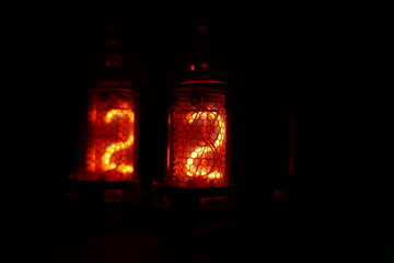 Retro Nixie lamp indicator clock on dark background. The Nixie tube indicator of the numbers of...