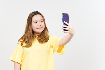 Take a Selfie using Smartphone of Beautiful Asian Woman wearing yellow T-Shirt Isolated On White