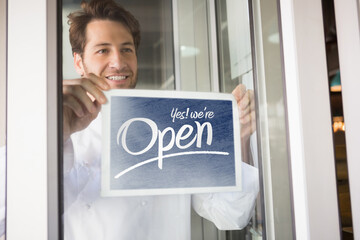 Cafe owner showing open sign