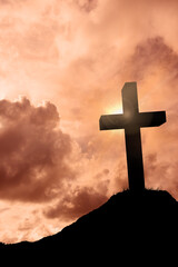 Naklejka premium Cross religion symbol shape over sunset sky 