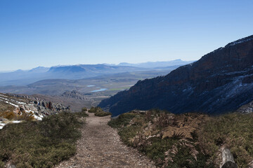 Path leading down into valley under bright sky