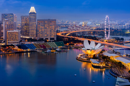 Singapore city in Marina Bay building area. Financial district and skyscraper buildings. Aerial view of Singapore at dusk.