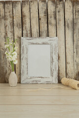 Photo frame and flower vase on table