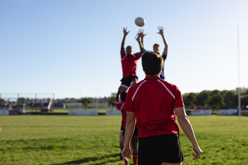 Rugby players raising their hands and catching the ball