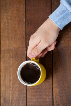 Man holding yellow coffee cup