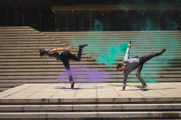 Young friends dancing on the street with smoke bombs