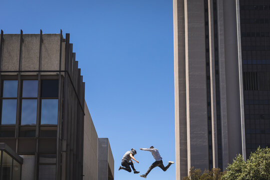 Caucasian men jumping on the street