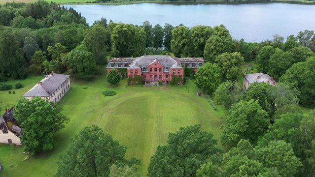Katvari manor abandoned Latvia red brick mansion building aerial rising pull back