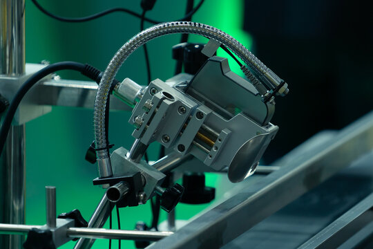 Fiber Optic Color Mark Sensor, Photoelectric Sensor with fiber optic technology installed on an industrial beverage processing machine in a factory.