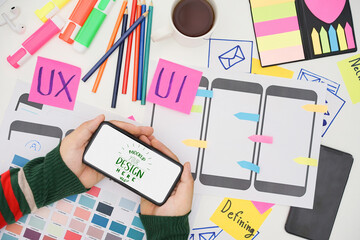 Creative top view photo of UX UI designer working space with mobile white screen mockup, white screen for graphic montage.