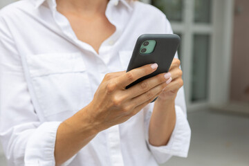 female hands hold a modern mobile phone on the street..education, modern app, shopping order, work online