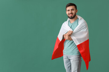 Handsome young man with flag of Poland on green background